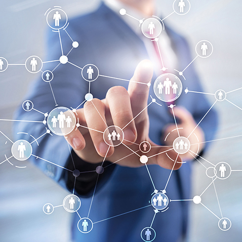 Person in suit touching a digital network of connected icons.